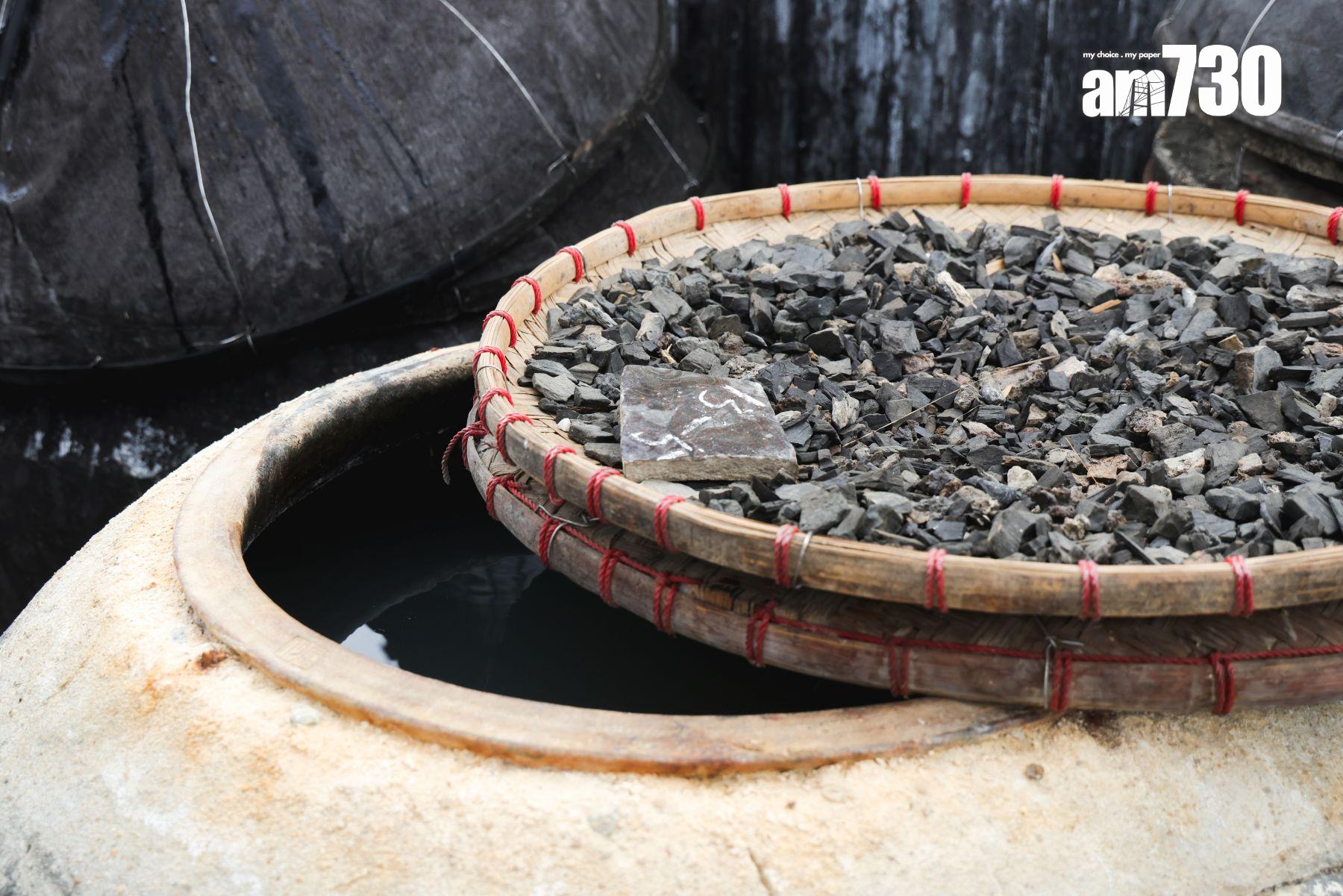 黃豆曬半年後,黃豆與豉酒分隔開,將豉油抽起放在盤上再曬多一至兩個星期,令水分揮發,豉油會更濃縮。(攝:吳康琦)