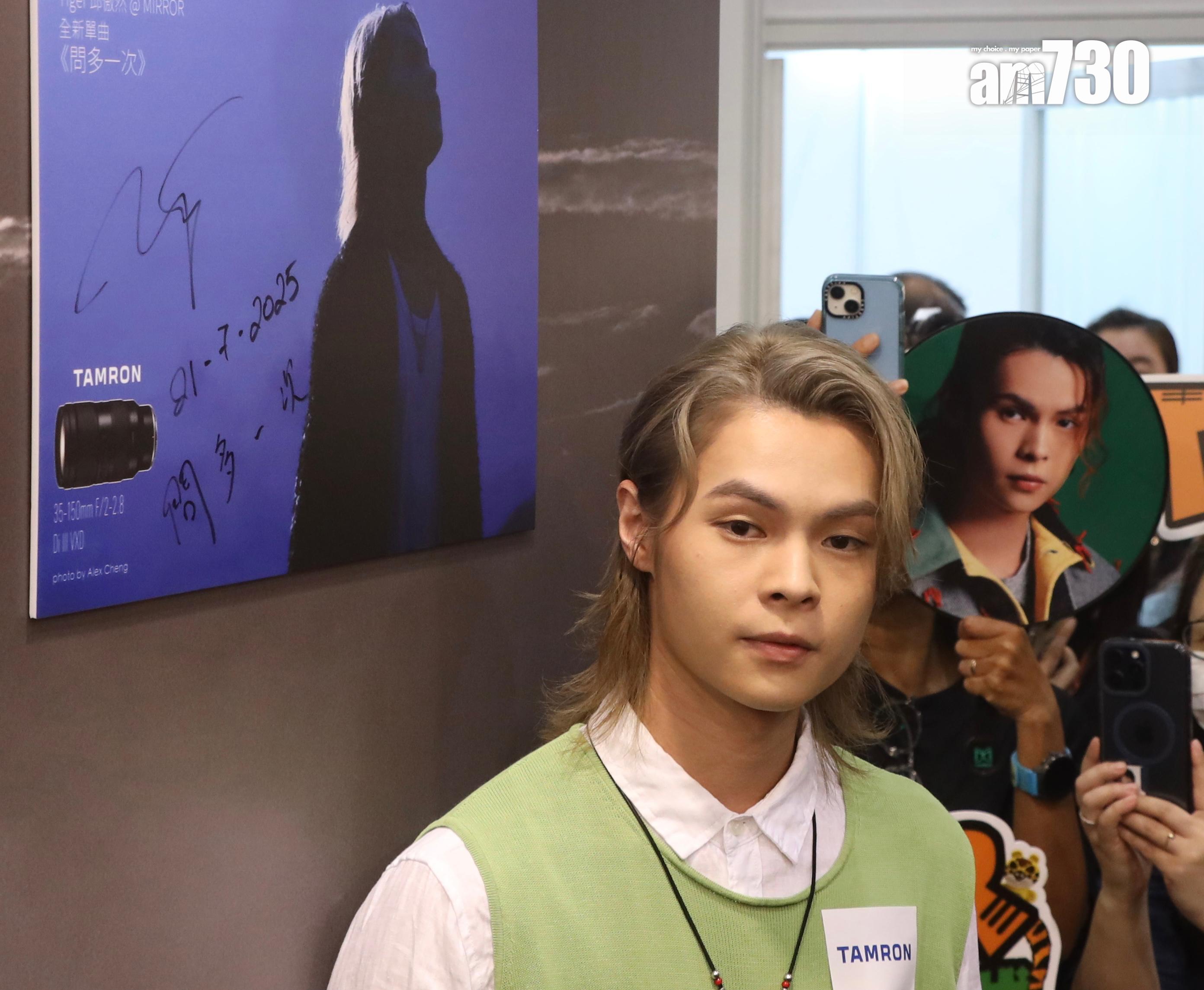 邱傲然Tiger@MIRROR即席在MV攝影展的作品上簽名留念。(娛樂組攝)