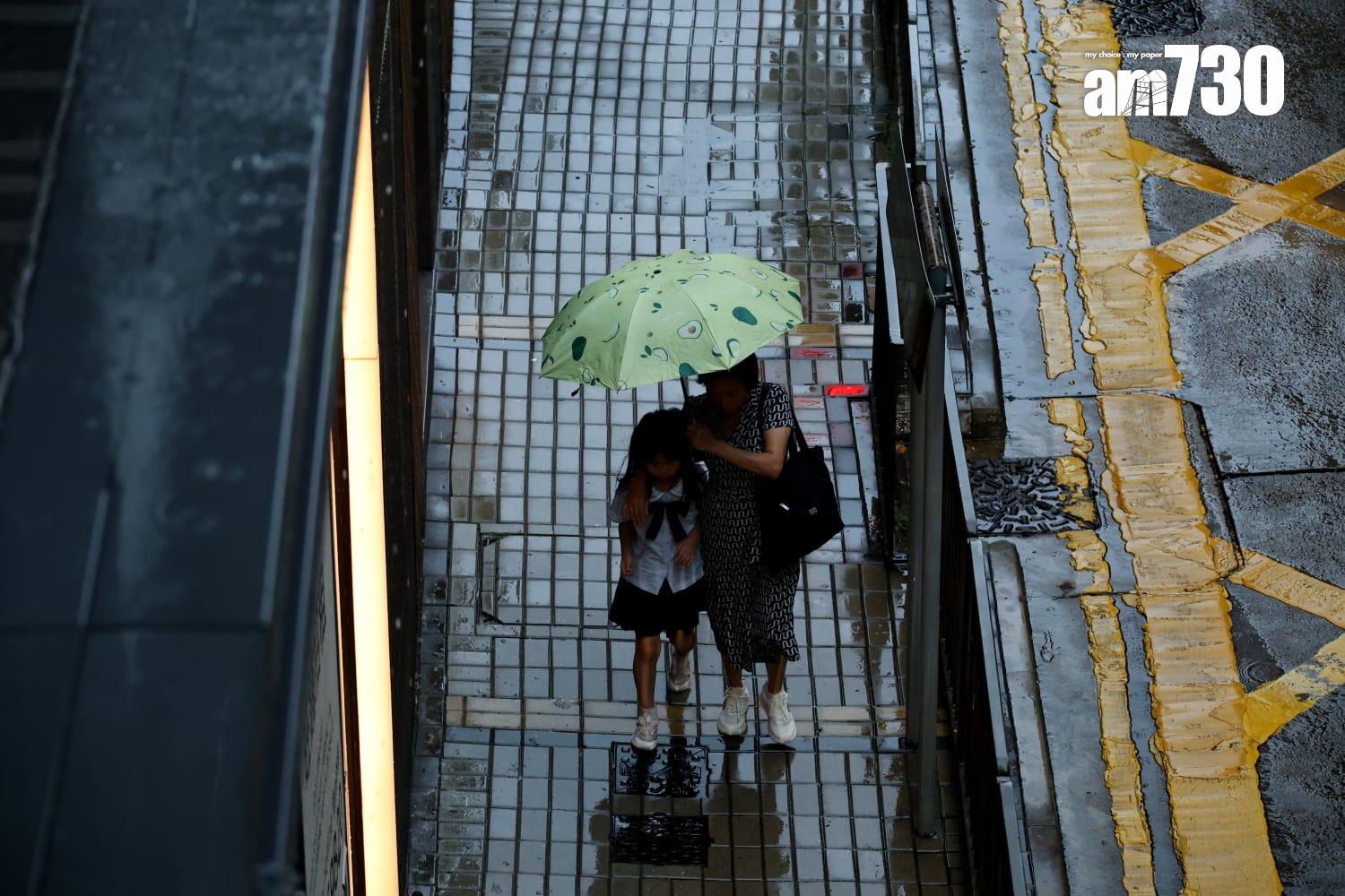 小學生及家長冒雨上學。(林俊源攝)