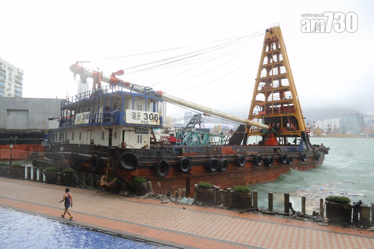 颱風樺加沙|紅磡海逸豪園對出海面,有躉船被吹至撞向岸邊擱淺,岸邊欄杆玻璃和石壆被毀,碎片散落行人徑。(鍾式明攝)