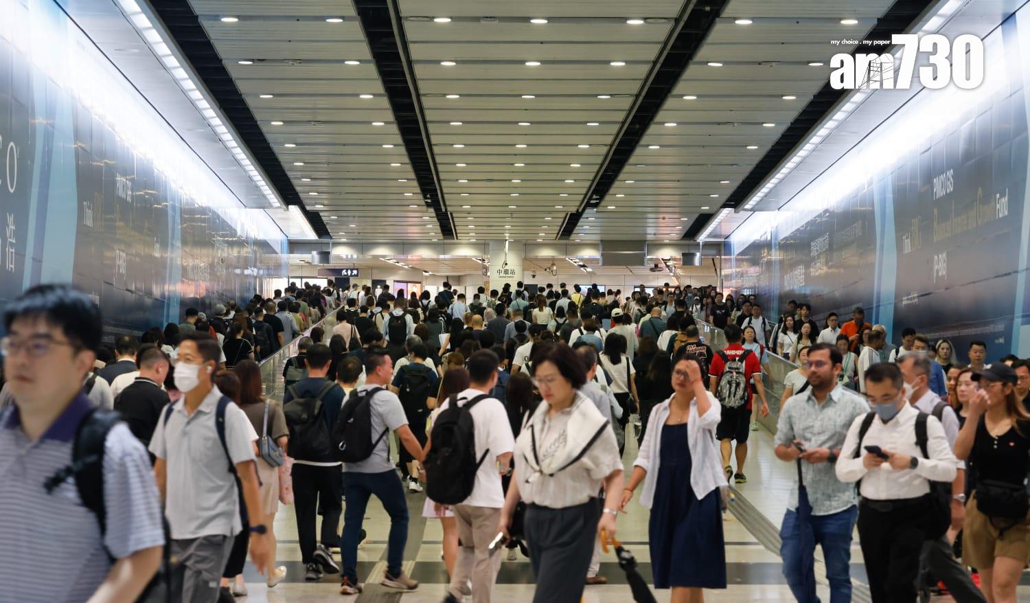 八號烈風或暴風信號會維持至下午1時10分,改掛三號強風信號,打工仔坐港鐵上班。(蘇文傑攝)