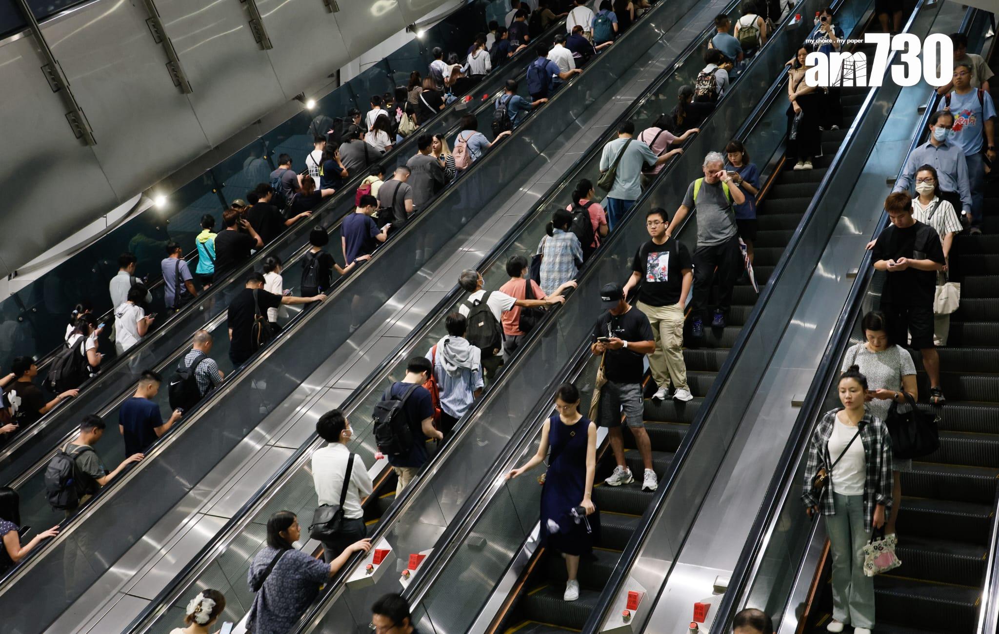 八號烈風或暴風信號會維持至下午1時10分,改掛三號強風信號,打工仔坐港鐵上班。(蘇文傑攝)