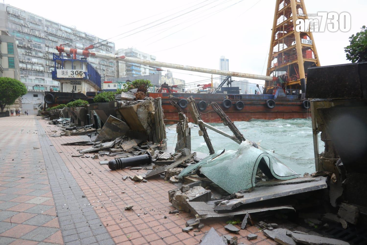 颱風樺加沙|紅磡海逸豪園對出海面,有躉船被吹至撞向岸邊擱淺,岸邊欄杆玻璃和石壆被毀,碎片散落行人徑。(鍾式明攝)