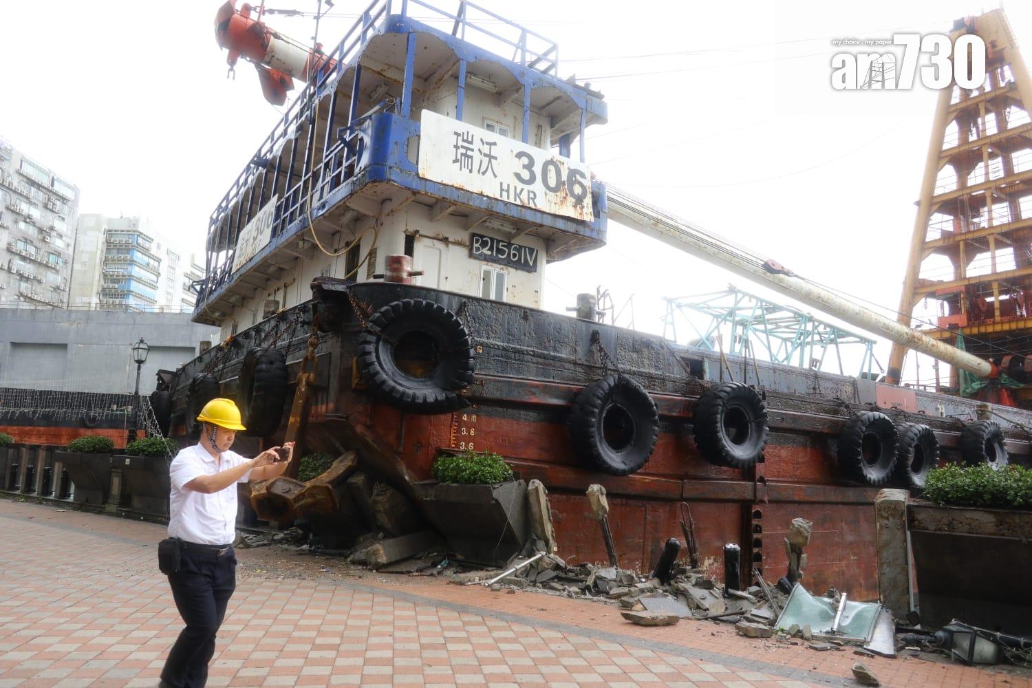颱風樺加沙|紅磡海逸豪園對出海面,有躉船被吹至撞向岸邊擱淺,岸邊欄杆玻璃和石壆被毀,碎片散落行人徑。(鍾式明攝)