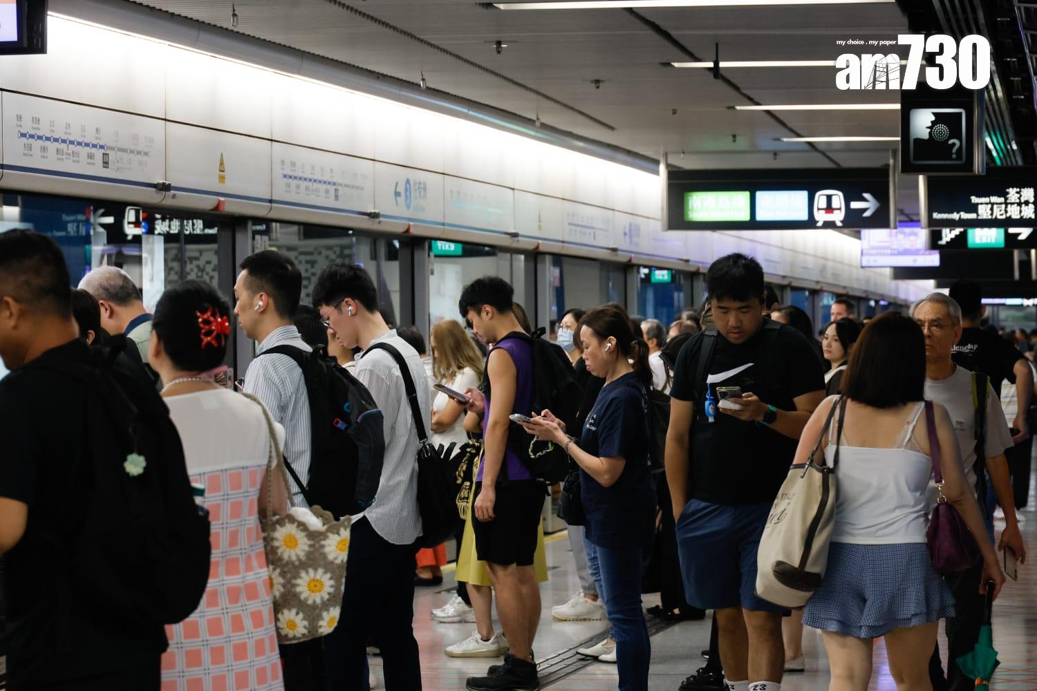 八號烈風或暴風信號會維持至下午1時10分,改掛三號強風信號,打工仔坐港鐵上班。(蘇文傑攝)