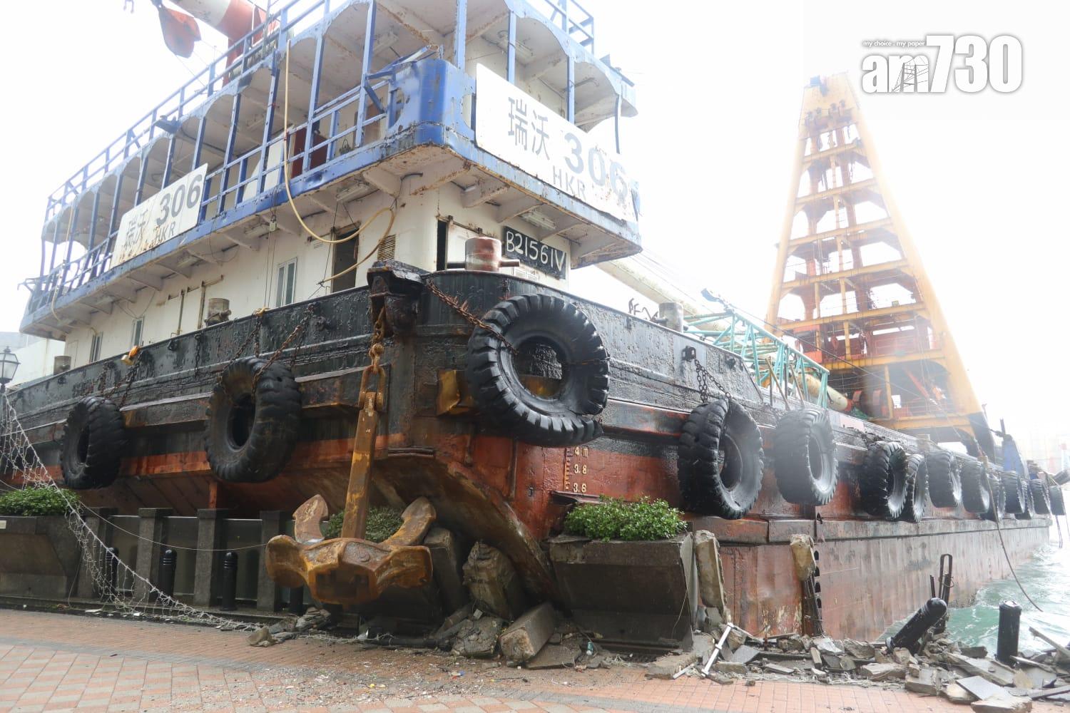 颱風樺加沙|紅磡海逸豪園對出海面,有躉船被吹至撞向岸邊擱淺,岸邊欄杆玻璃和石壆被毀,碎片散落行人徑。(鍾式明攝)
