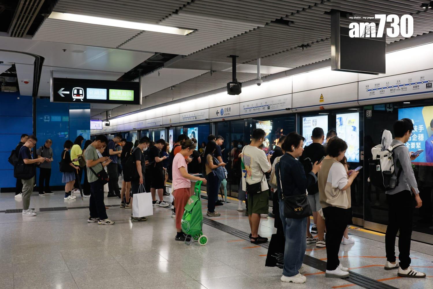 八號烈風或暴風信號會維持至下午1時10分,改掛三號強風信號,打工仔坐港鐵上班。(蘇文傑攝)