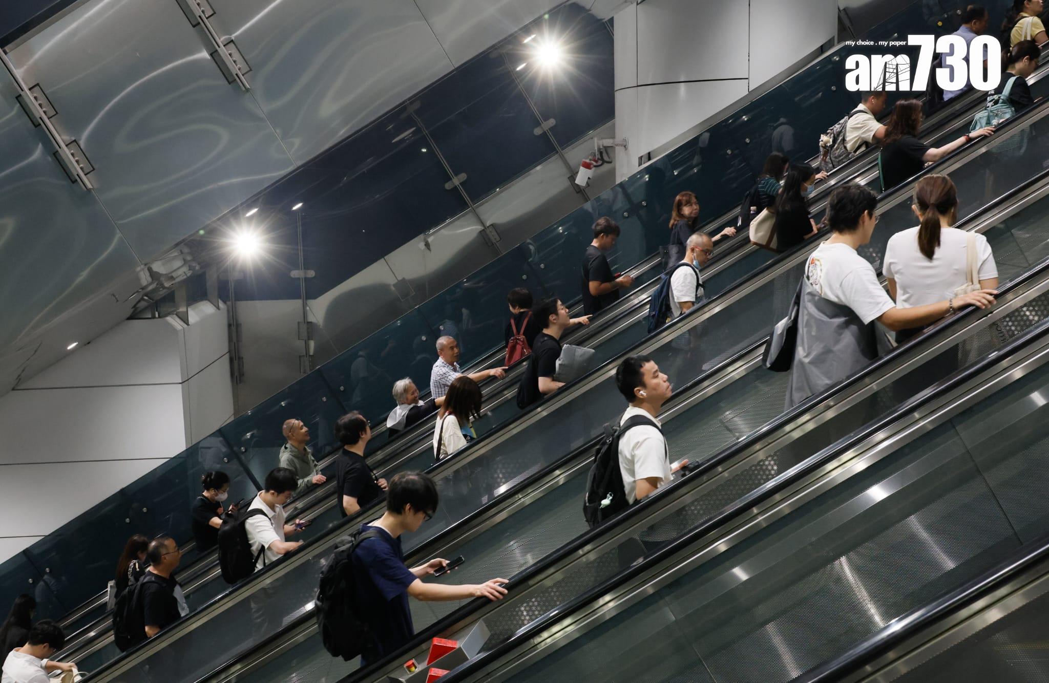 八號烈風或暴風信號會維持至下午1時10分,改掛三號強風信號,打工仔坐港鐵上班。(蘇文傑攝)