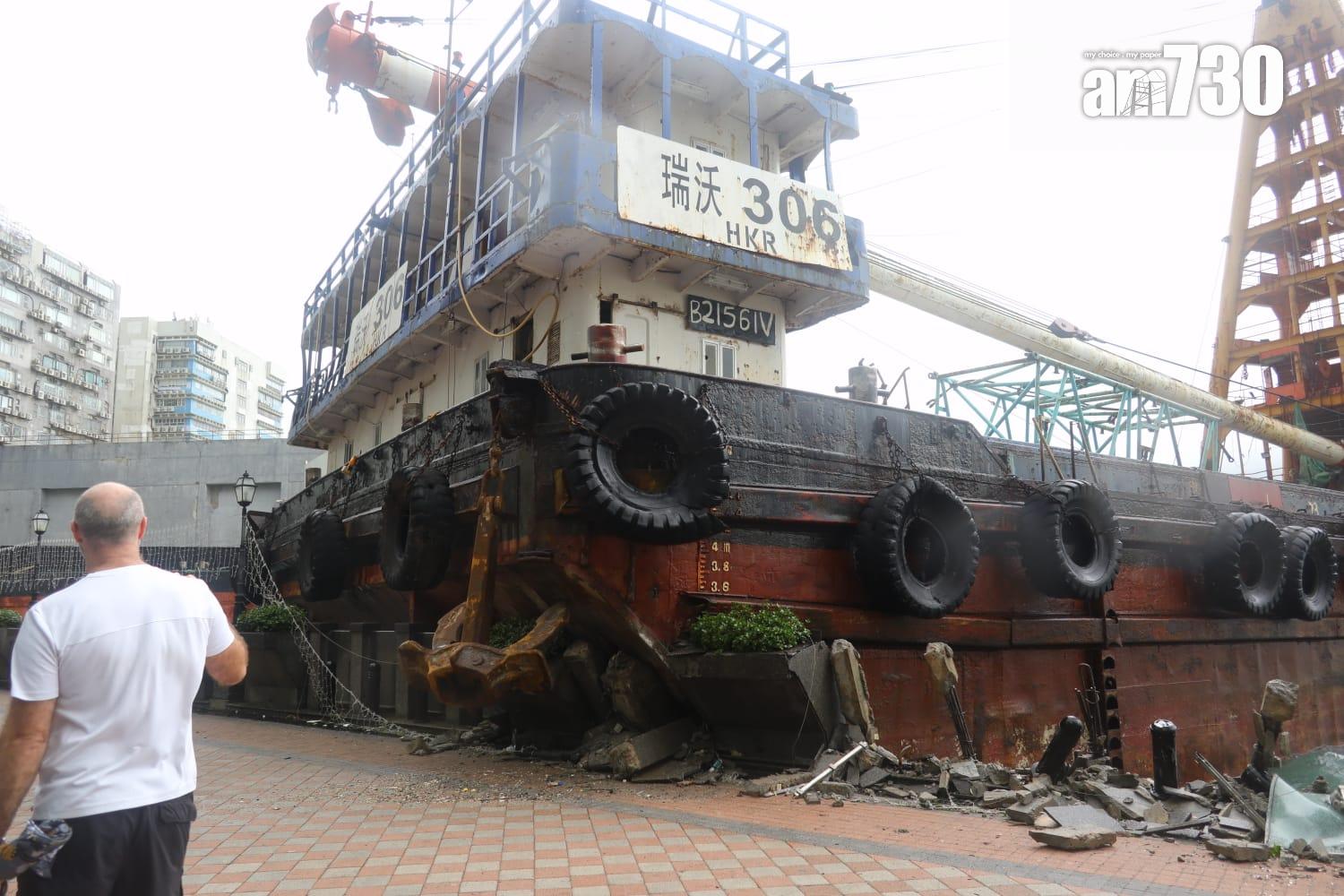 颱風樺加沙|紅磡海逸豪園對出海面,有躉船被吹至撞向岸邊擱淺,岸邊欄杆玻璃和石壆被毀,碎片散落行人徑。(鍾式明攝)