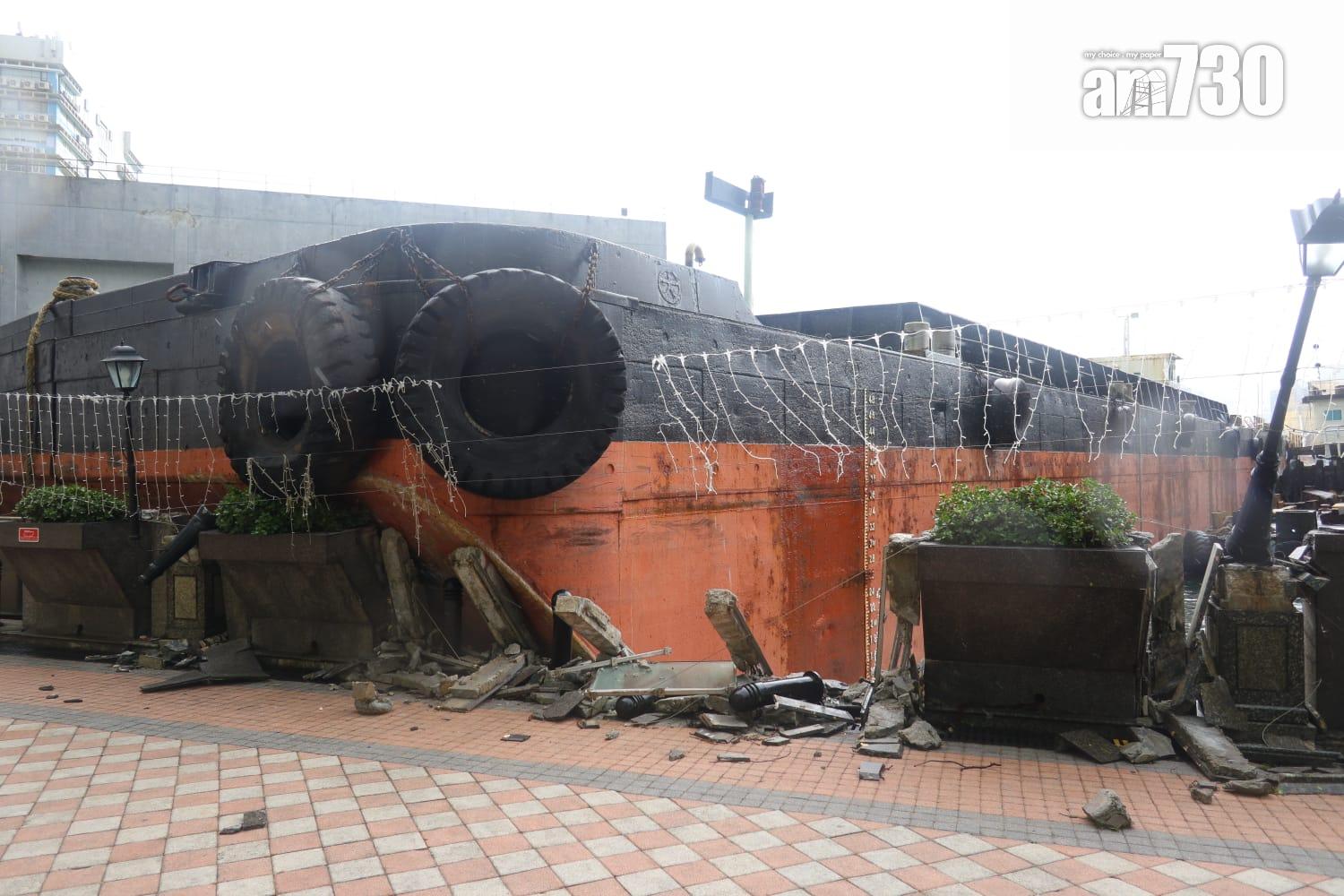 颱風樺加沙|紅磡海逸豪園對出海面,有躉船被吹至撞向岸邊擱淺,岸邊欄杆玻璃和石壆被毀,碎片散落行人徑。(鍾式明攝)