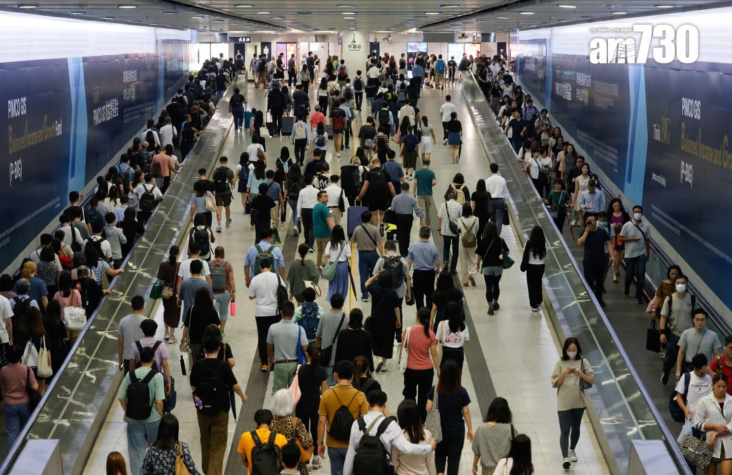 八號烈風或暴風信號會維持至下午1時10分,改掛三號強風信號,打工仔坐港鐵上班。(蘇文傑攝)