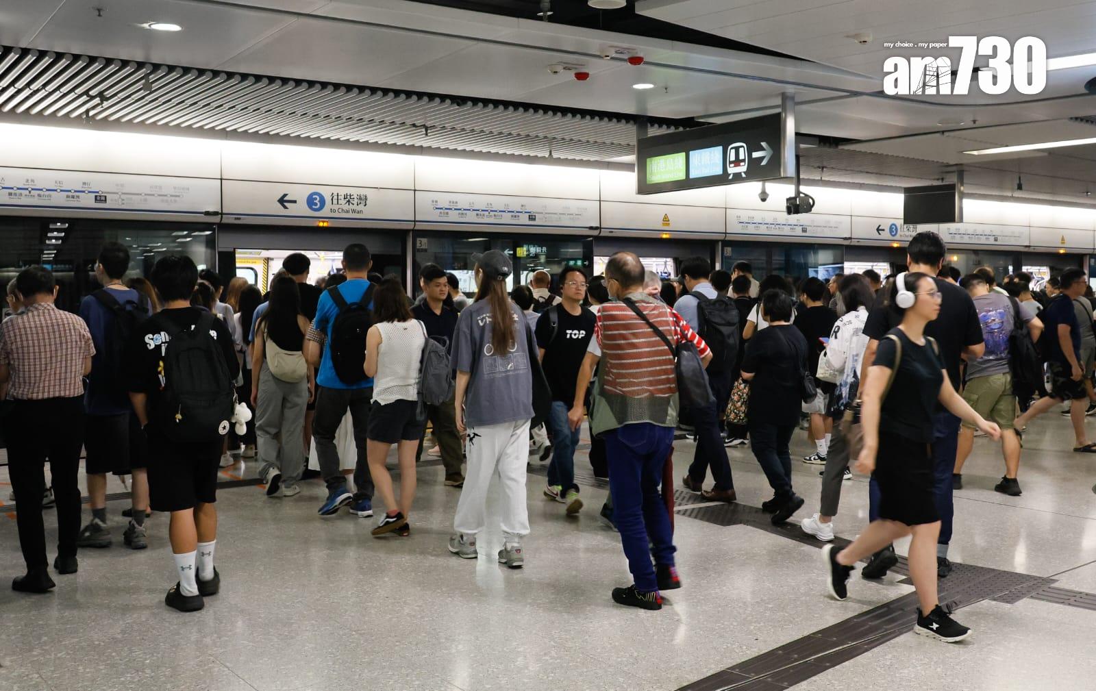 八號烈風或暴風信號會維持至下午1時10分,改掛三號強風信號,打工仔坐港鐵上班。(蘇文傑攝)