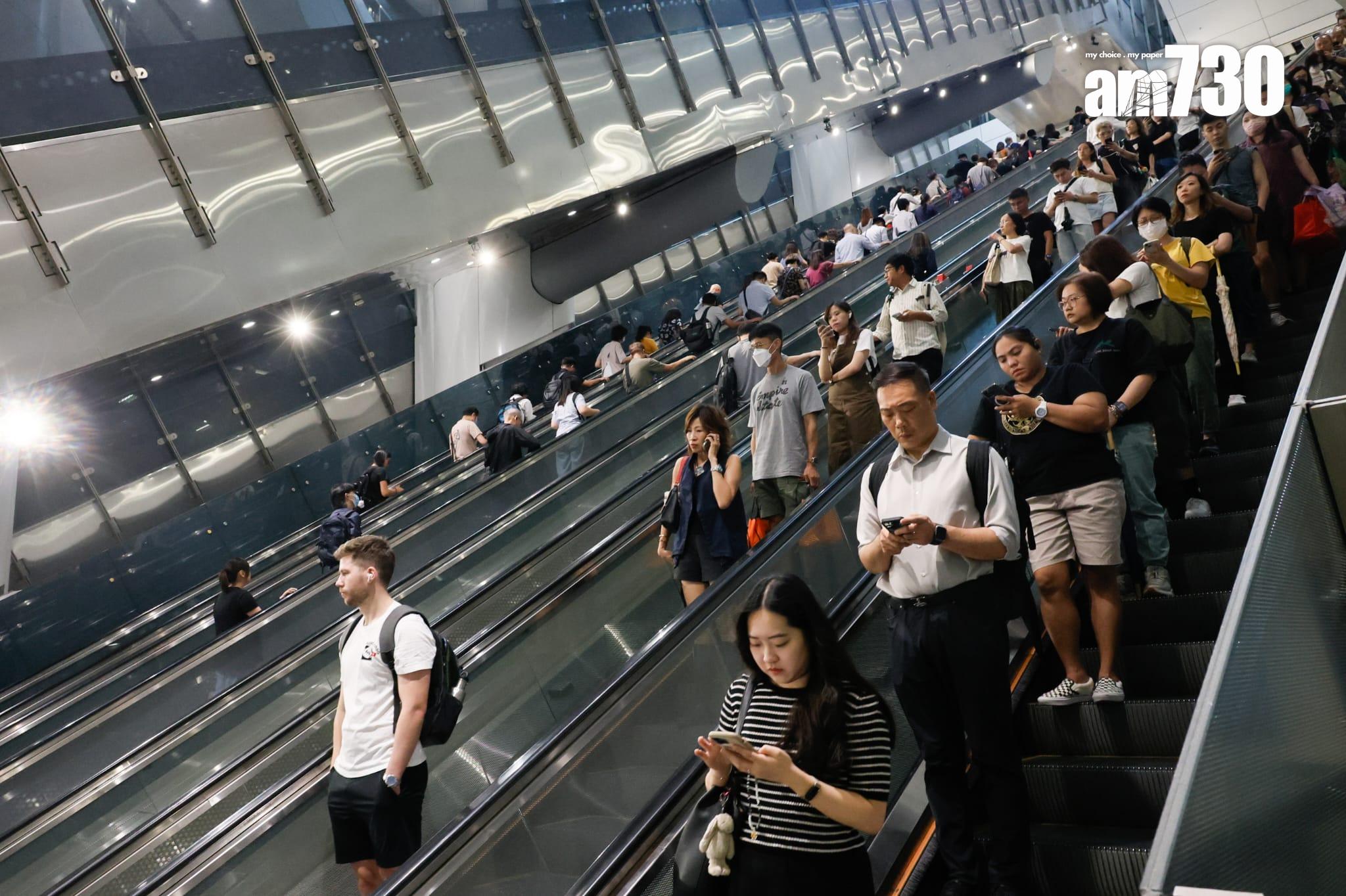 八號烈風或暴風信號會維持至下午1時10分,改掛三號強風信號,打工仔坐港鐵上班。(蘇文傑攝)