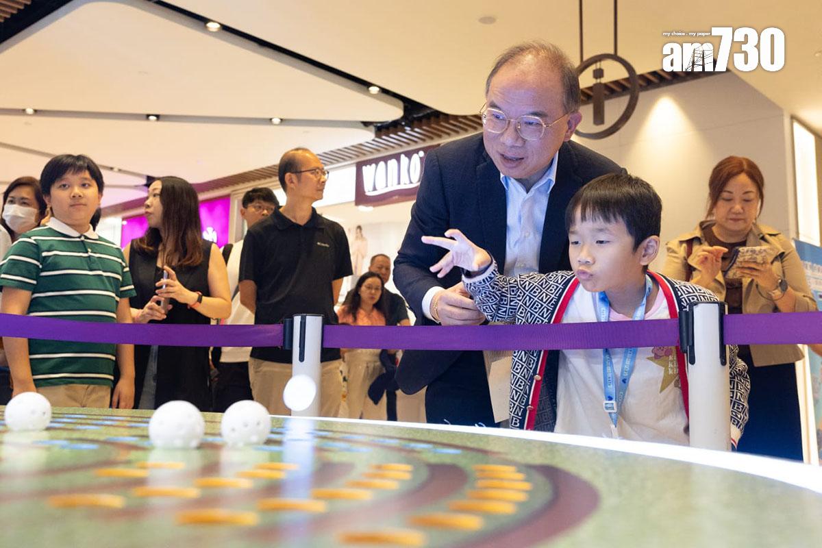 曾國衞(右二)在「選舉進社區」展覽與市民玩遊戲。(蘇文傑攝)