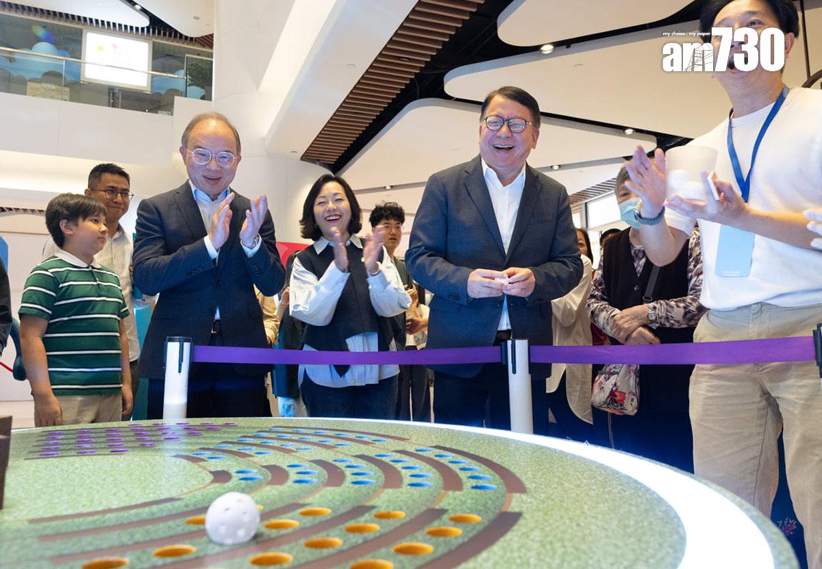 陳國基(右二)與曾國衞(左二)、麥美娟(中)在「選舉進社區」展覽試玩遊戲。(蘇文傑攝)