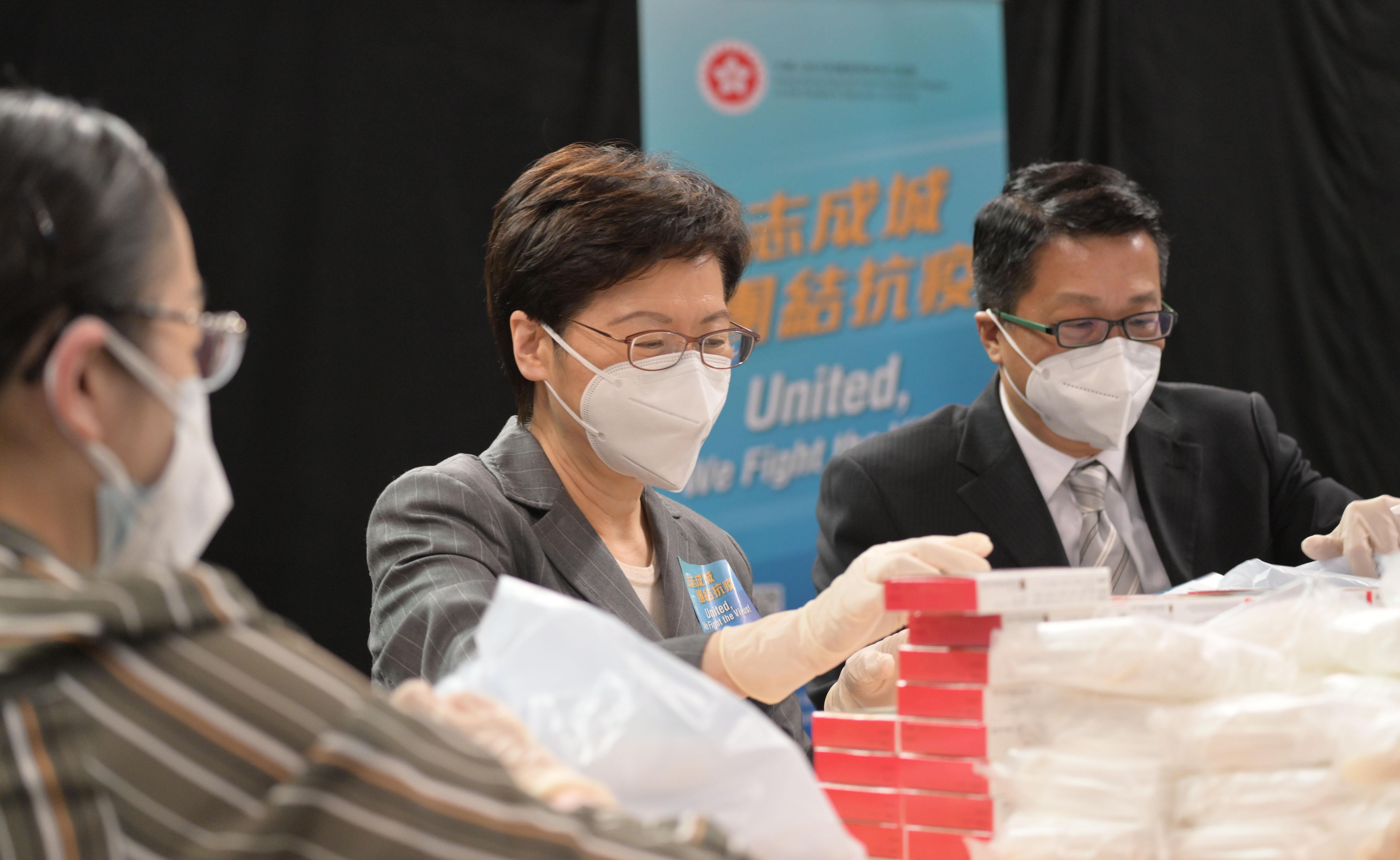 特首林鄭月娥(中)及民政事務局署理局長陳積志(右)昨落手包裝「防疫服務包」。(資料圖片／政府新聞處)
