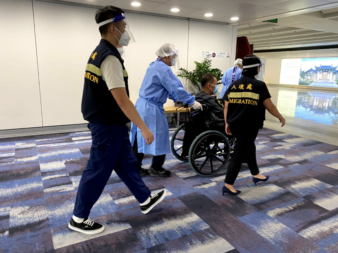 一名求助港人安全抵達香港國際機場，圖示入境處人員在場協助。
