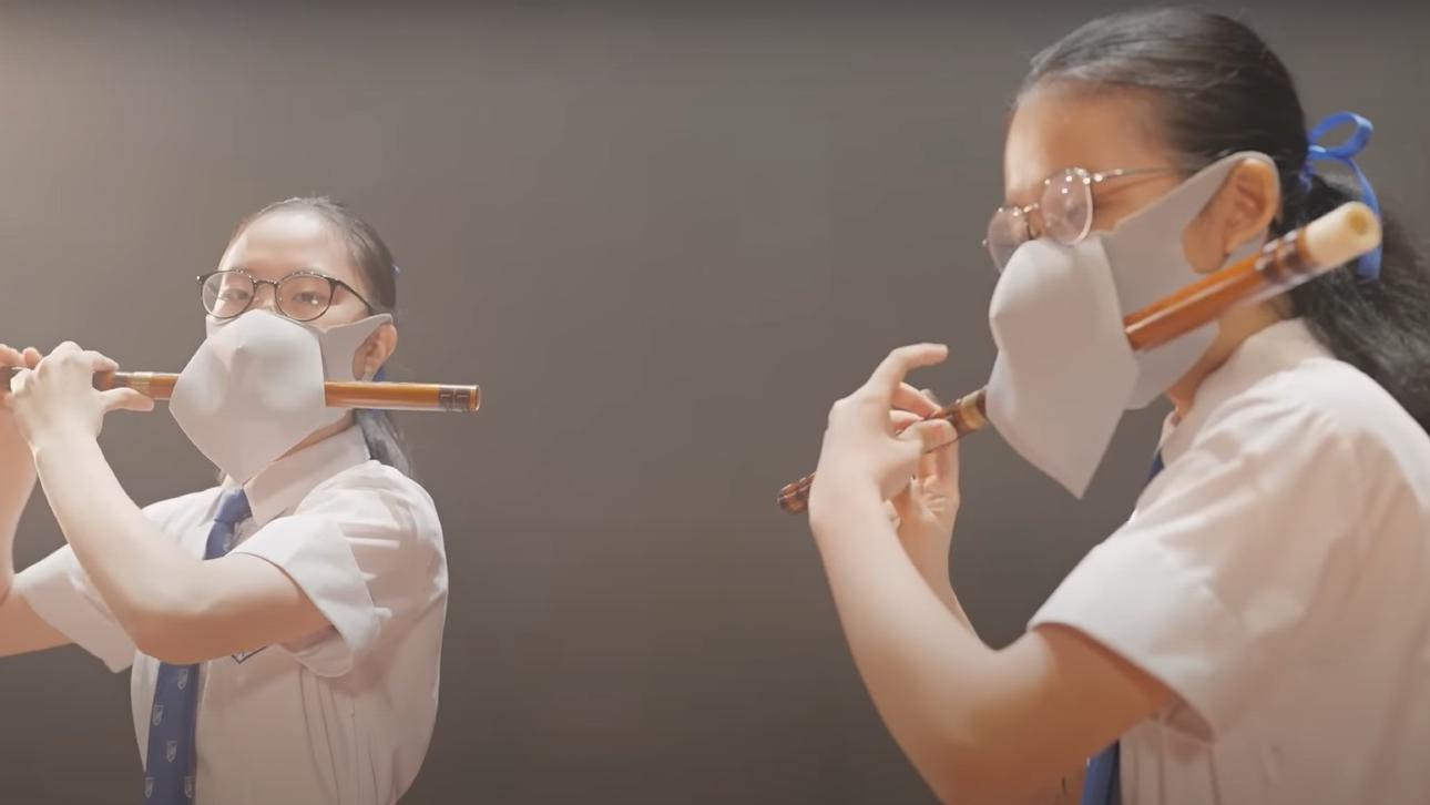 片中兩名女學生「戴罩吹笛」。(網片截圖)