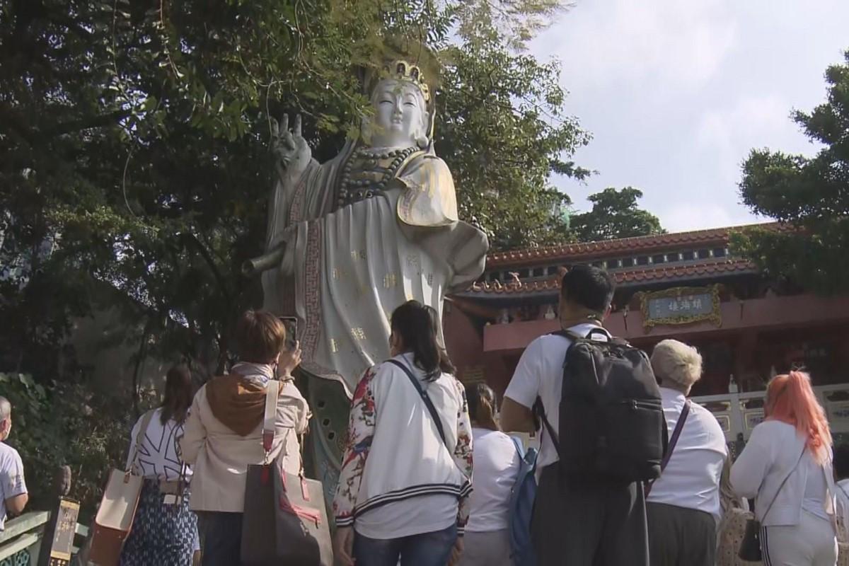 疫情下首個訪港旅行團來自泰國，今日先後到訪淺水灣和紅磡的廟宇。(電視截圖)