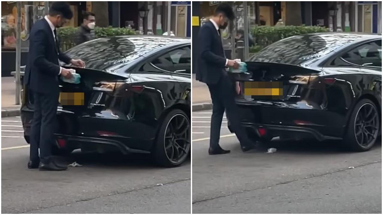 西裝男用濕紙布抹Tesla，再將紙巾踢入車底。(網片截圖)