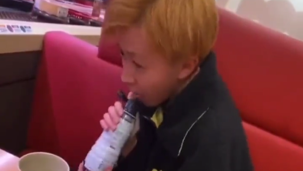 青年舔豉油的樽口。(影片截圖)