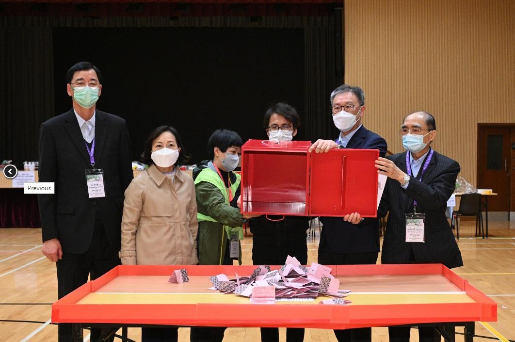 選管會主席陸啟康法官（右二）、民政及青年事務局局長麥美娟（左二）、選管會委員陸貽信資深大律師（右一）和石丹理教授（左一）今日（一月八日）在二○二三年鄉郊一般選舉村代表選舉設於將軍澳順德聯誼總會梁潔華小學的點票站，倒出投票箱中的選票。 