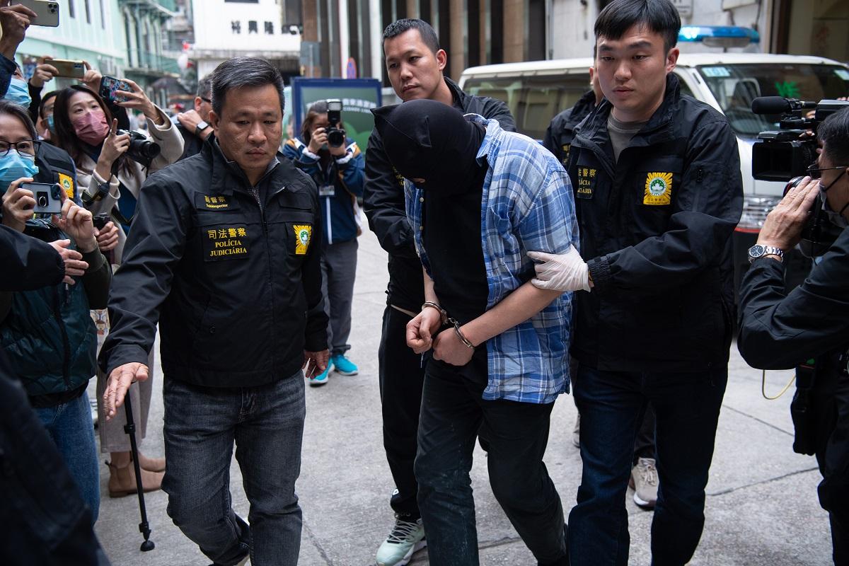 司警將一名香港籍男疑犯押返案發現場重組案情。(中通社)