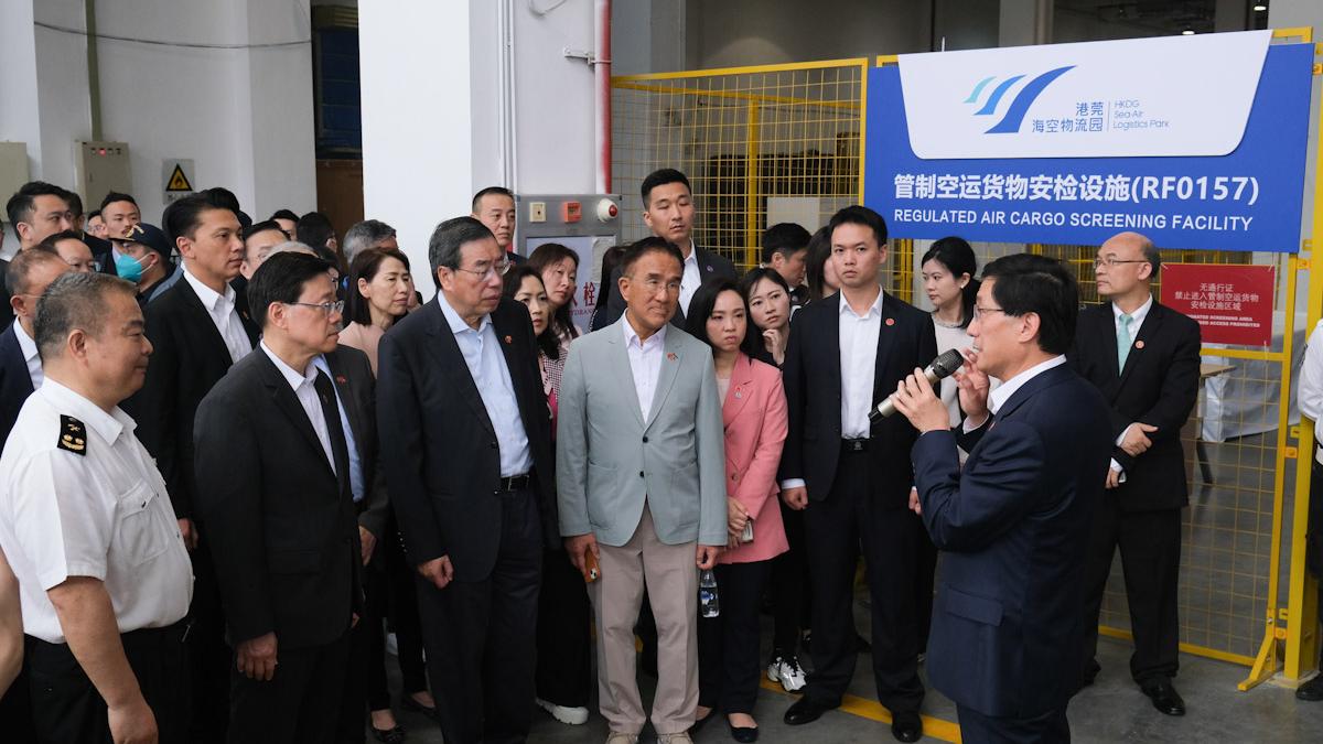 李家超(前排左二)聽取關於東莞物流園的貨物安檢設施。(羅庸軒攝)