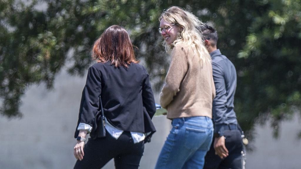 霍姆斯由兩人陪同下向監獄報到。(美聯社)