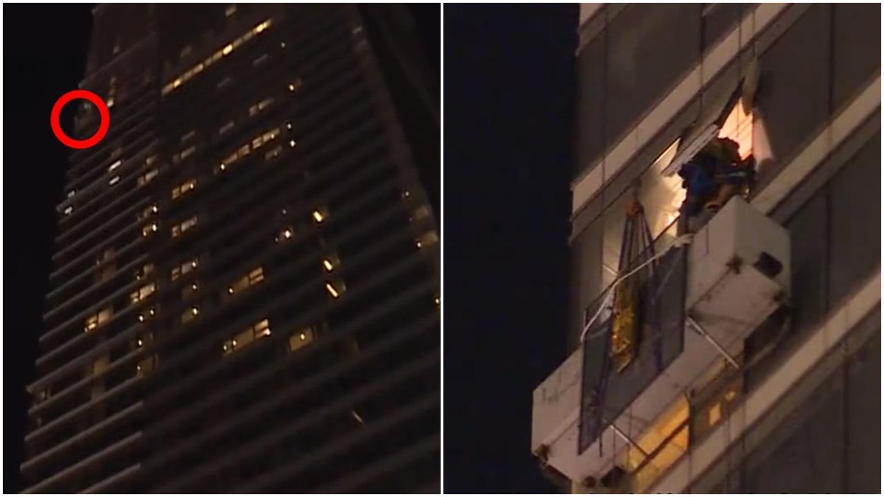 九龍站天鑽璽發有吊船半空故障，2工人被困逾2小時後獲救。(電視截圖)