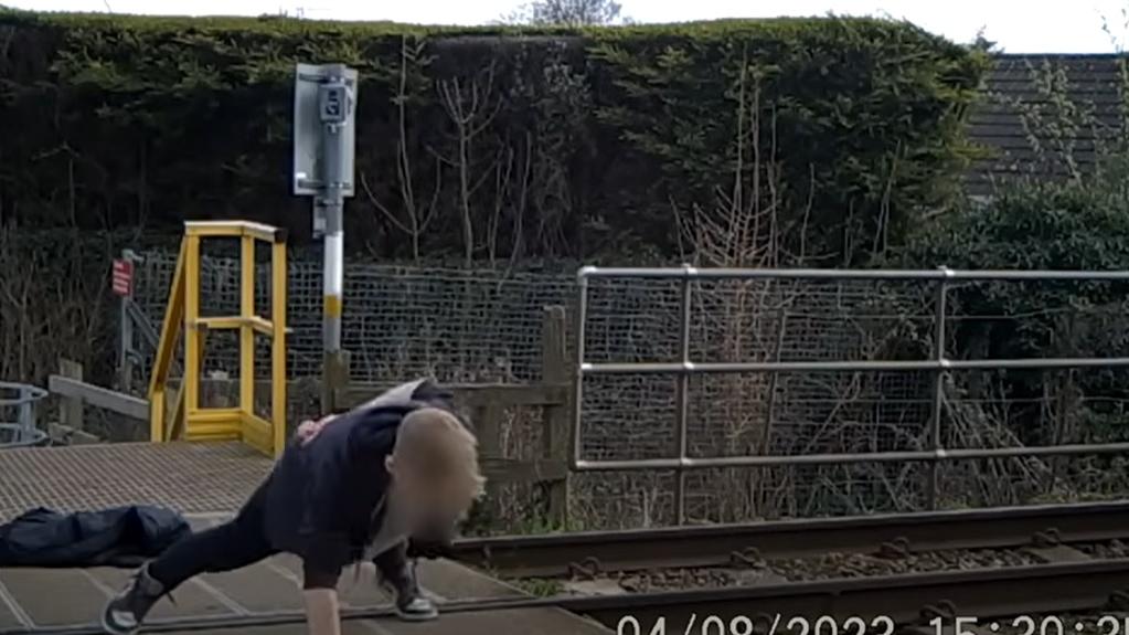 在鐵道過路處做單手掌上壓。(互聯網)