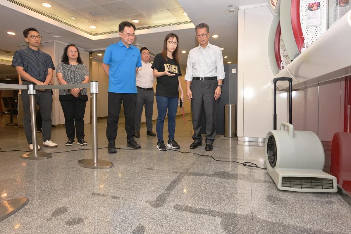 陳茂波(右一)到一間銀行分行，視察在極端天氣後的營運情況。(陳茂波FB)