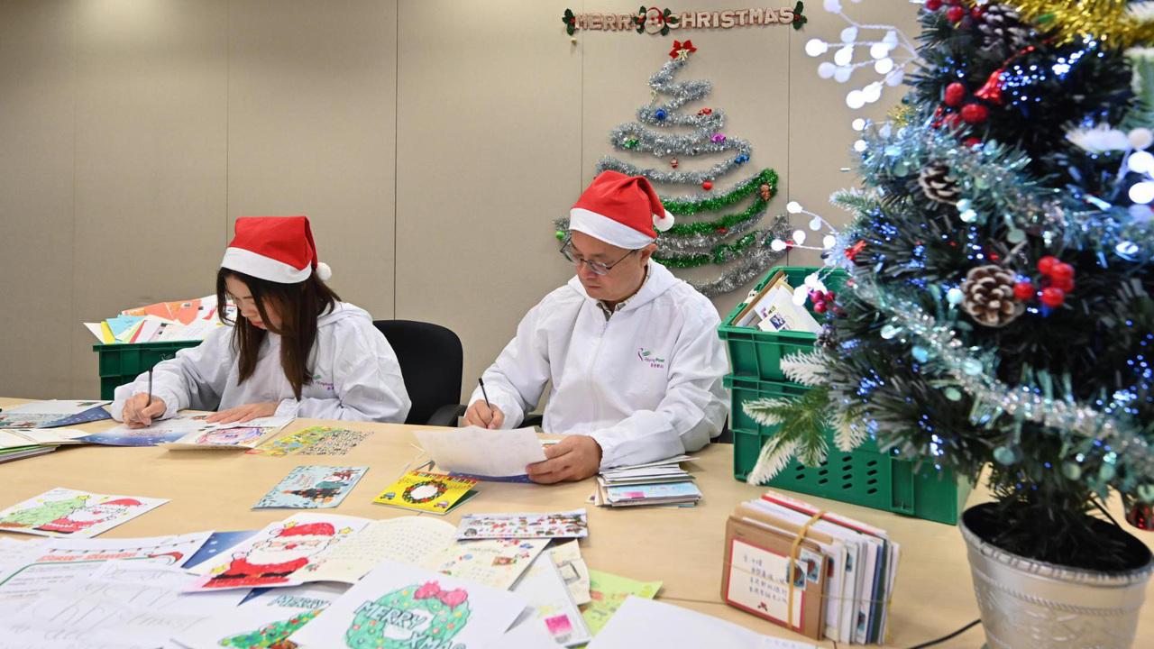 香港郵政每年收到約6,000封來自世界各地、寄給聖誕老人的信件和聖誕卡，署方在過去40年都安排職員，以聖誕老人身分逐一親筆回信，送上祝福。郵務主任劉嘉紹及郵務員郭頌羚，今年繼續負起這項回信任務。(政府新聞網)