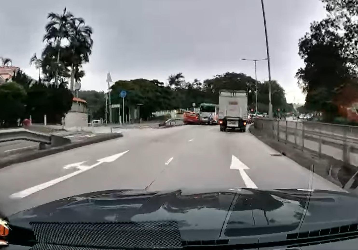  紅色私家車意圖攝慢線與鐵欄空隙。(@fb香港突發事故報料區/Bosco Chu圖片)