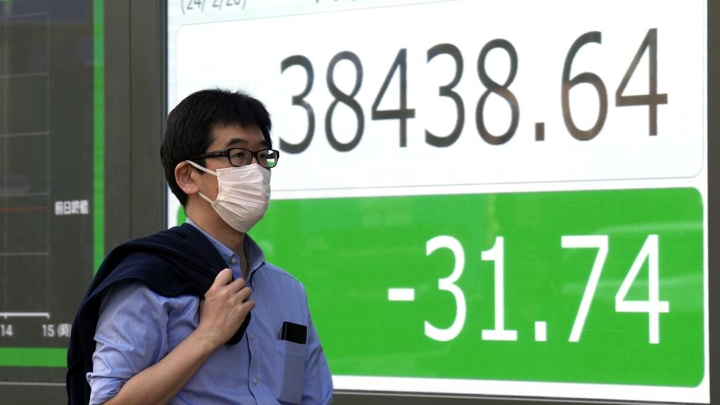 東京近日和暖，有民眾在街上熱得脫掉外套。(美聯社)