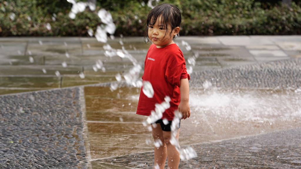 美國德州達拉斯周二天氣和暖，一名兩歲女童到公園戲水。(美聯社)