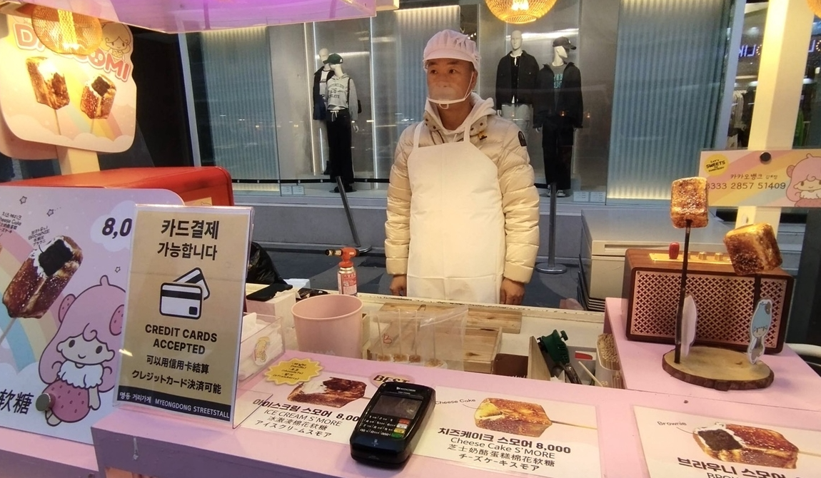 南韓著名景點明洞的路邊小食檔，引入信用卡付款，並定期進行價格監控，避免出現向遊客濫收費用、服務態度差和要求只付現金等爭議，以恢復旅客的信任。 (網上圖片)