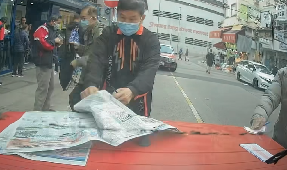 的士司機未有出言提醒便開車駛走，兩名馬迷隨即作出反應，將馬經及投注飛捉實，但仍有數張投注飛遺留在車尾冚上。（facebook群組「馬路的事討論區」影片截圖）