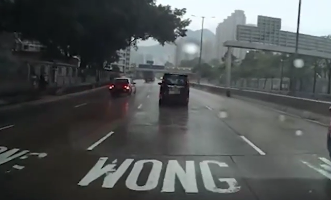 一輛黑色私家車行駛期間甩轆。(片段截圖)