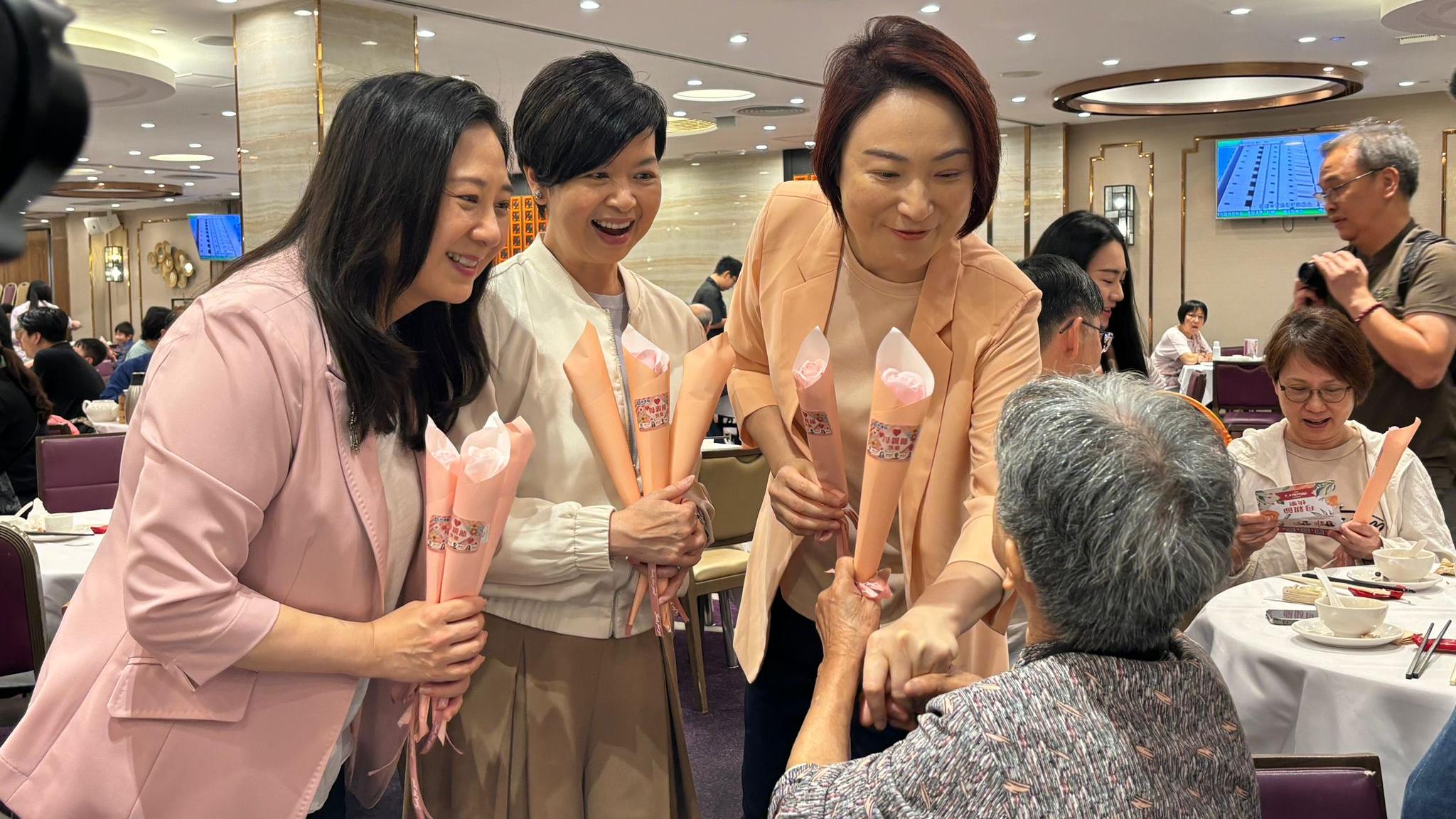 何永賢(中)、李慧琼(右)及葛珮帆(左)到酒樓派花。(林嘉瑩攝)