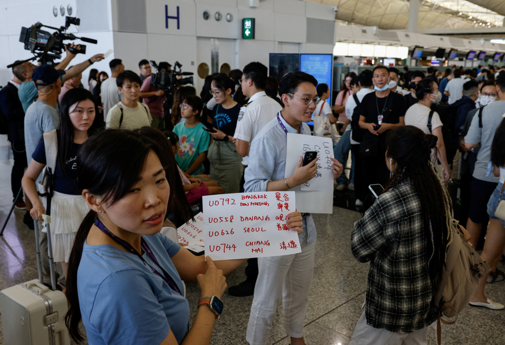 位於香港國際機場的自助辦理登機手續設施以及機場櫃位登機系統受到影響，航空公司為旅客人手辦理登機手續。(路透社)