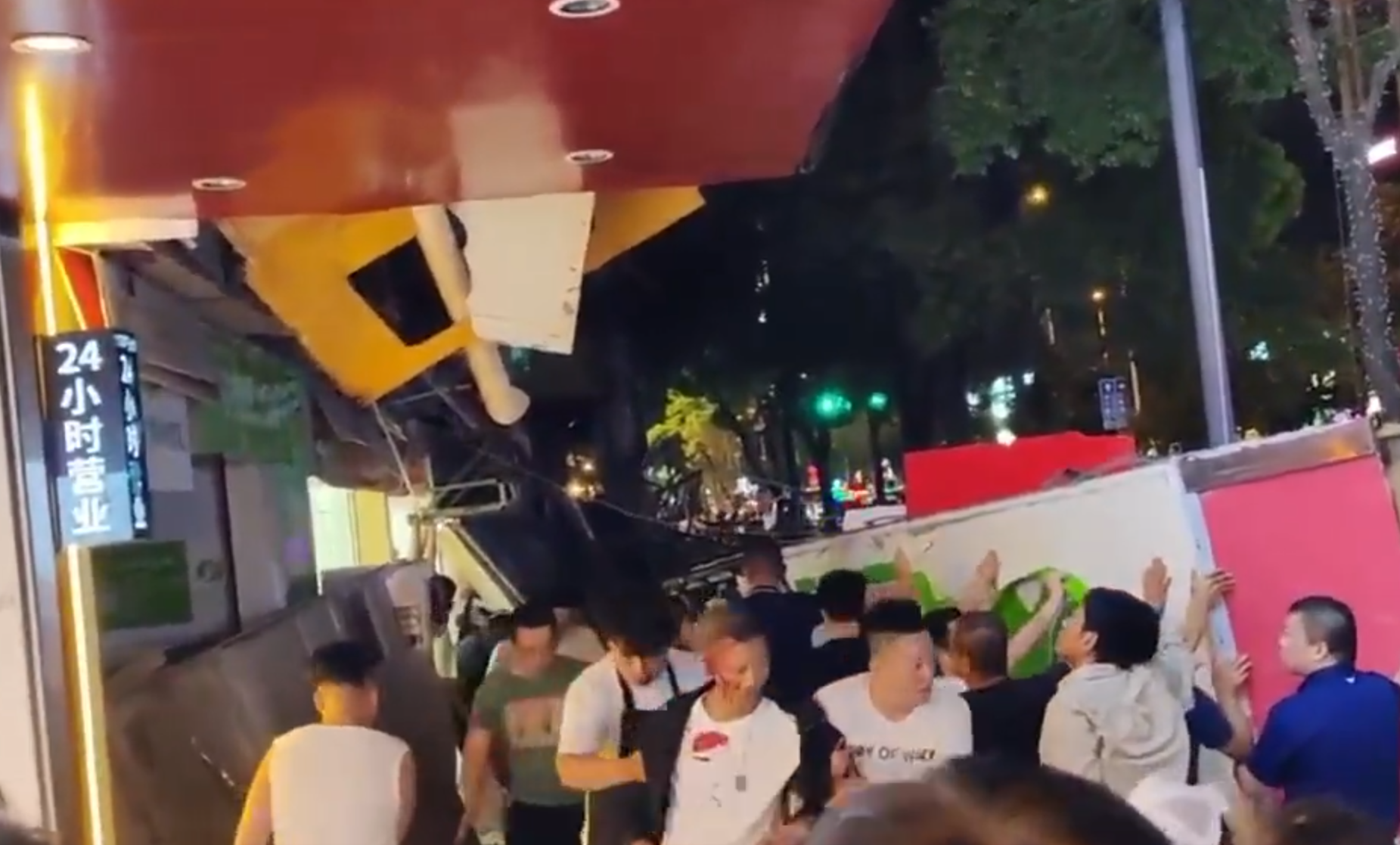 昆明商舖廣告牌5樓墮地釀3死7傷，附近市民合力抬起招牌救人。