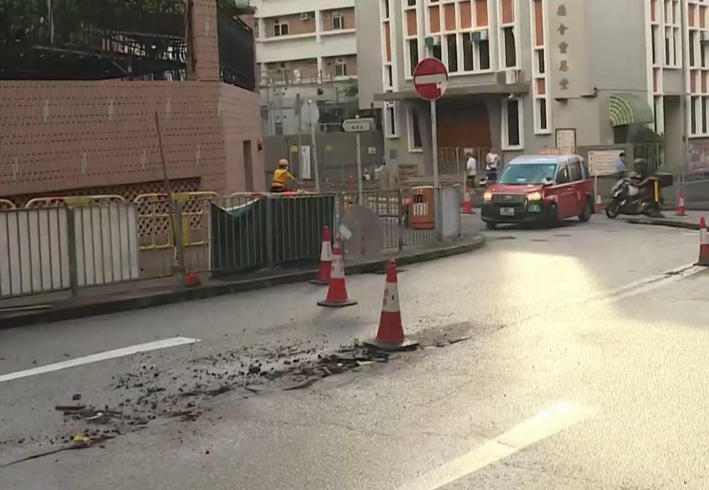 廣播道爆水管致路陷，水務署人員到場關水掣。(電視截圖)