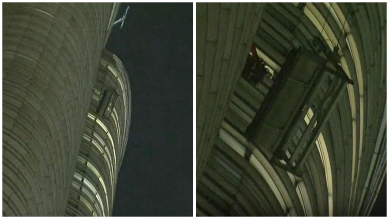 東半山曉廬吊船故障，2清潔工被困60樓高空2小時。(電視截圖)