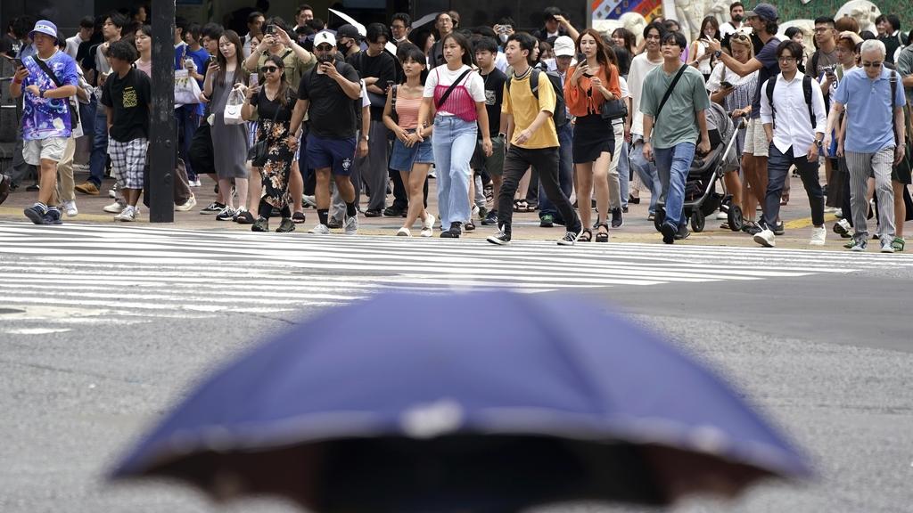 東京炎熱不退，圖為當地近日陽光猛烈，民眾外出時撐傘擋太陽。(資料圖片)