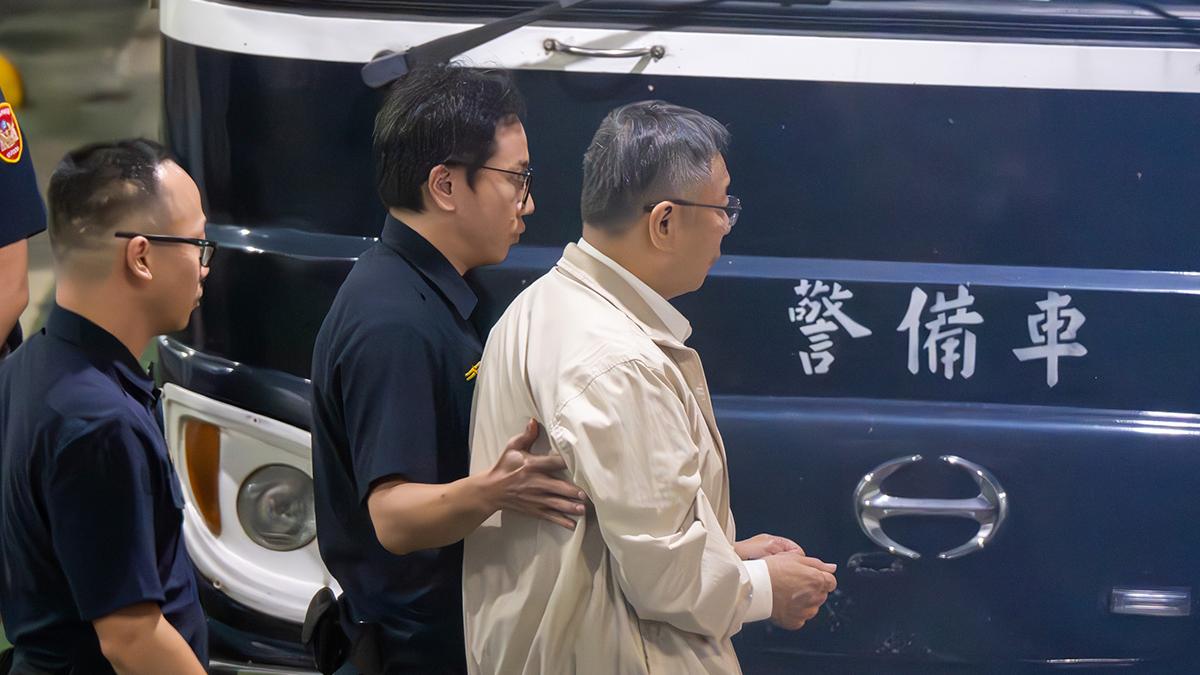 柯文哲被羈押庭裁定羈押禁見後步上囚車。(中通社)