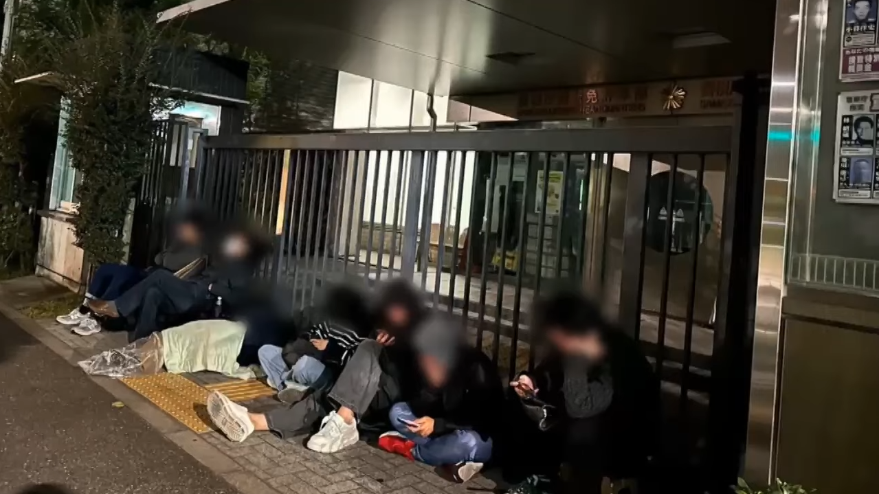 日本電視台在東京的一個駕駛中心外排隊準備申請更換日本駕駛執照。(新聞截圖)