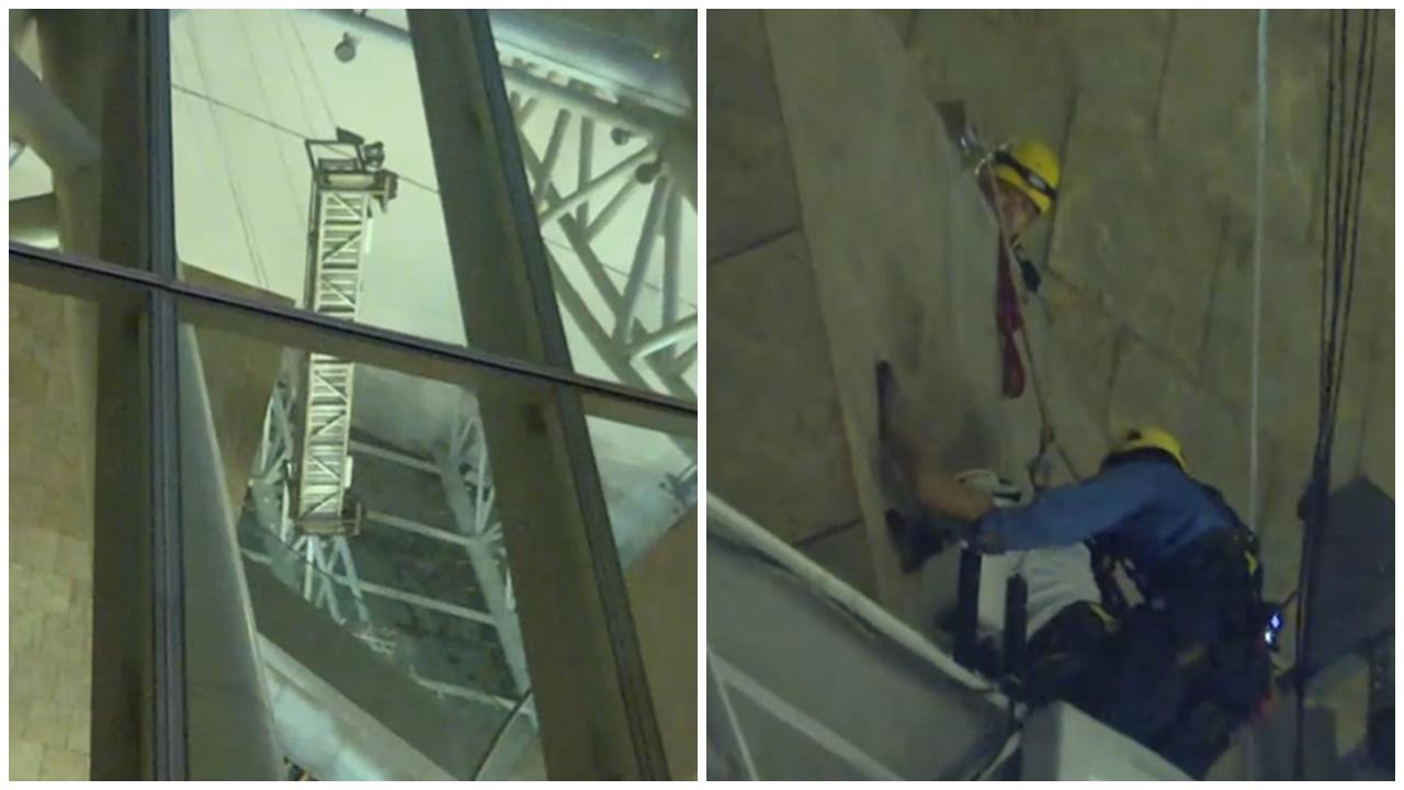 朗豪坊吊船機件故障，2男工半天吊由消防游繩救回。(電視截圖)