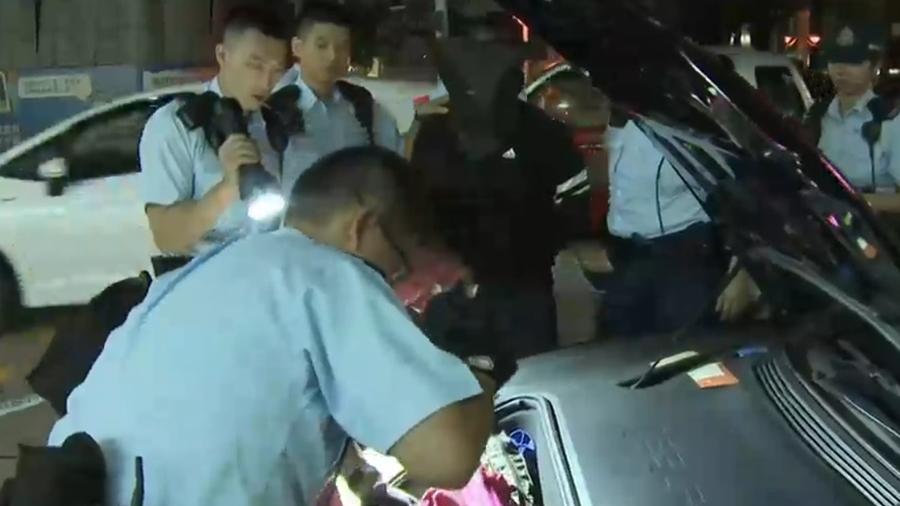 尖沙咀Tesla衝路障，男司機棄車扮途人被捕，檢獲數張偽鈔。(電視截圖)