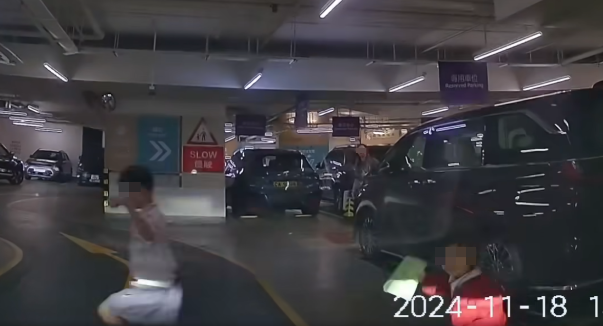 當時車主正駕車準備離開，駛至前往商場的升降機附近通道時，突有一男一女小童打橫於一輛車後方的通道「殺出」  「車cam L（香港群組）」
